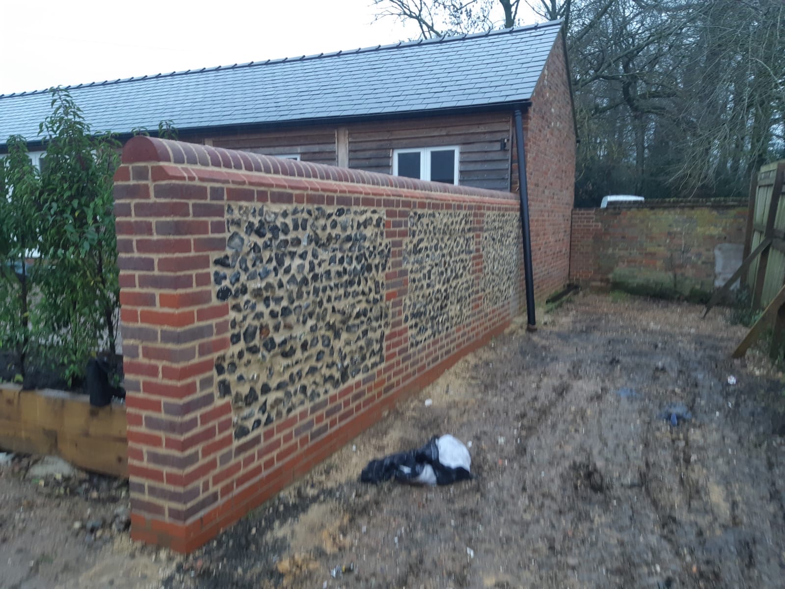 Heritage flint and brick garden wall with curved coping